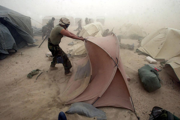 Các binh lính dựng lại lều sau khi một trận bão cát quét qua khu vực đóng quân của họ.