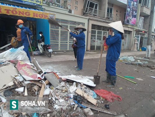 
Đồ đạc bị hư hỏng sau vụ nổ được chất thành nhiều đống lớn quanh hiện trường. Các nhân viên vệ sinh môi trường phải quét gọn vào thành đống.
