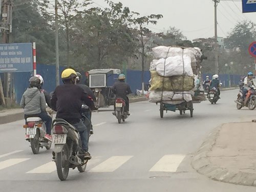 
Hàng hóa chất cao trên chiếc xe ba bánh chạy trên đường Kim Giang
