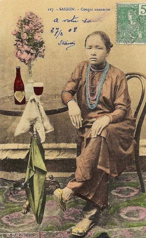 Một phụ nữ Sài Gòn xưa trong bộ áo dài nâu và chuỗi vòng hạt dài.