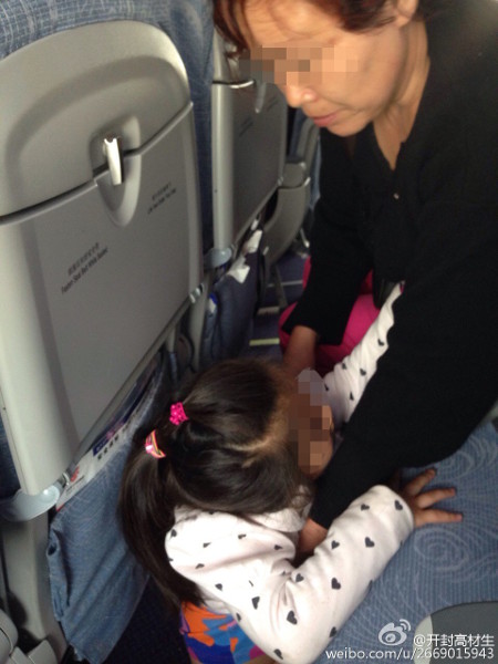 
Một phụ nữ cho cháu gái đi vệ sinh trên sàn máy bay. Ảnh: Weibo
