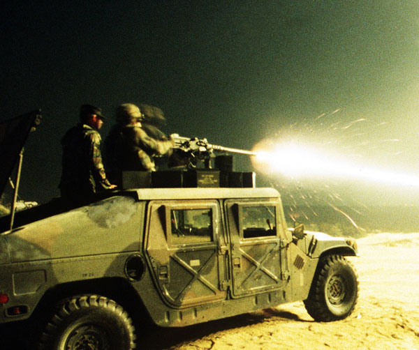 
Khẩu súng máy hạng nặng 12,7 mm trên nóc xe thiết giáp Humvee đốt cháy màn đêm với ánh lửa lóe sáng khi viên đạn rời khỏi nòng súng.
