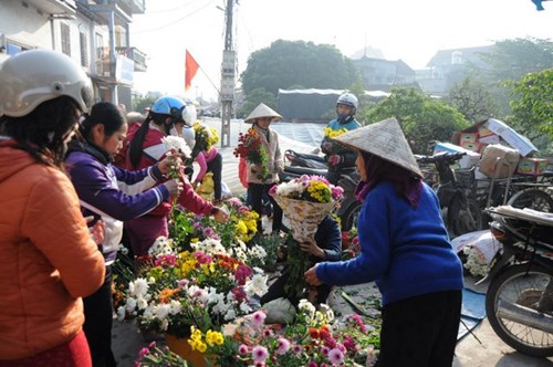 
Nhộn nhịp nhất vẫn là khu bán hoa. Ai cũng muốn đến sớm để chọn những bông hoa đẹp nhất để trưng bày trên bàn thờ tổ tiên.
