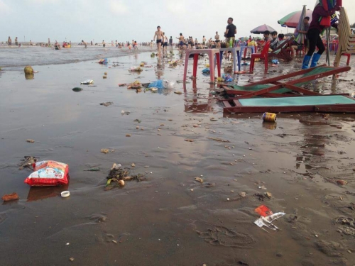 Trong ảnh, có thể thấy người dân vô tư vui chơi còn bãi biển thì ngập rác nào là vỏ dừa, túi nilon, vỏ bim bim…