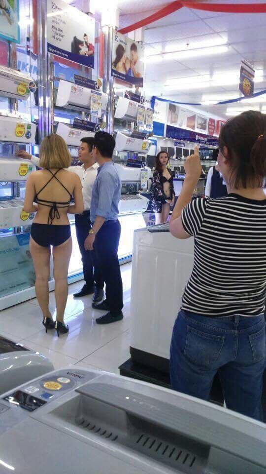 Cảnh cho nữ nhân viên mặc bikini giới thiệu sản phẩm tại siêu thị T.A