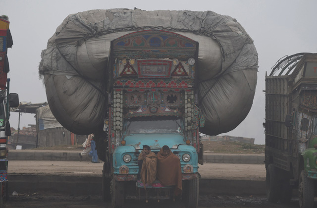 
Chiếc xe tải chất đầy hàng hóa di chuyển trong một ngày mù sương ở Lahore, Pakistan.
