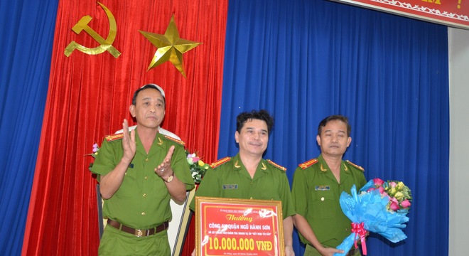 
Đại tá Trần Mưu (ngoài cùng bên trái) trao tặng số tiền 10 triệu đồng cho Công an quận Ngũ Hành Sơn. Ảnh: Bảo Ngọc.
