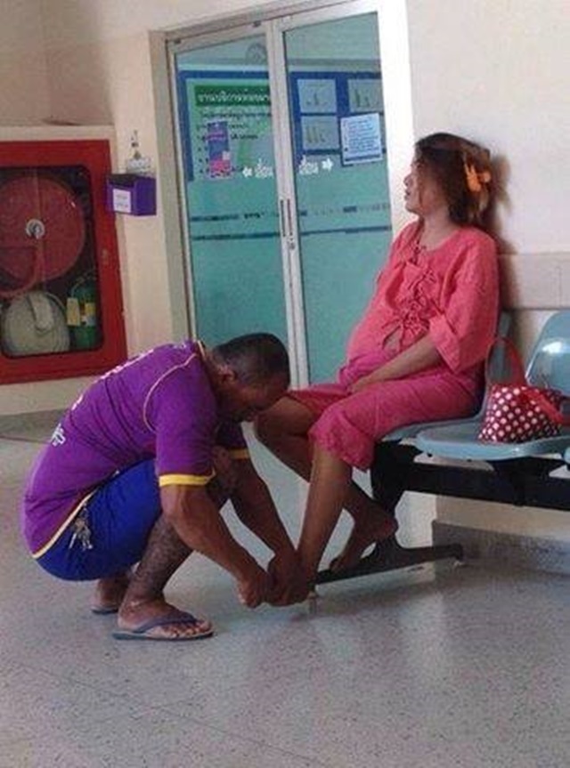 
Chồng bóp chân cho vợ đang mang bầu trong hành lang bệnh viện.
