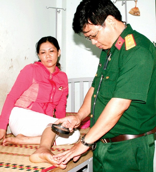 
Bác sĩ Vũ Ngọc Lương đang thăm khám một nạn nhân bị rắn độc cắn tại Trại Rắn Đồng Tâm.
