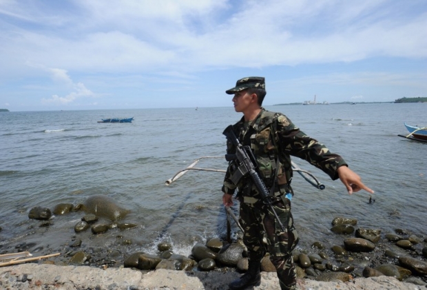 
Một quân nhân Philippines đứng gần bến tàu ở thị trấn Masinloc, tỉnh Zambales, Philippines, cách bãi cạn Scarborough 230 km. Bãi cạn này đã bị Trung Quốc chiếm sau sự kiện căng thẳng hồi năm 2012. (Ảnh: AFP)
