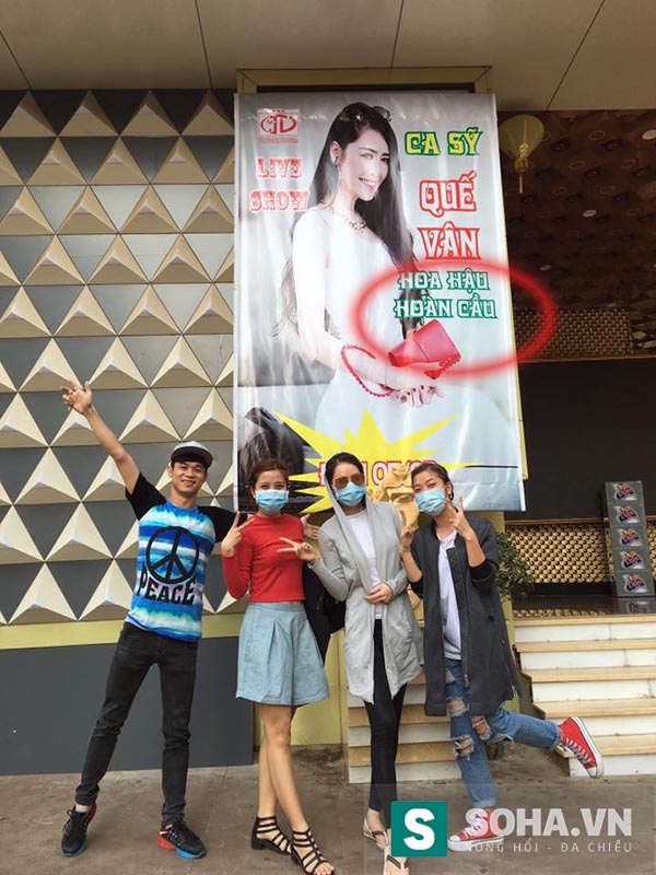 Hình ảnh Quế Vân cùng các vũ công đeo khẩu trang chụp hình với tấm poster đầy nghi vấn.