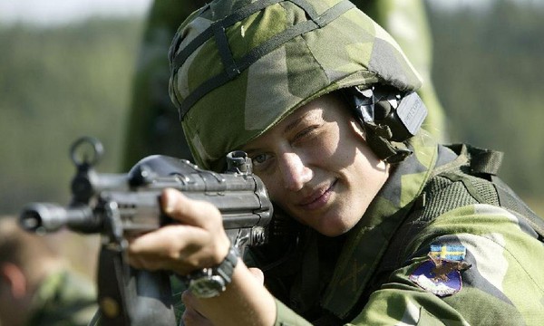 Dù tay cầm súng, nữ quân nhân này vẫn không mất đi vẻ nữ tính.