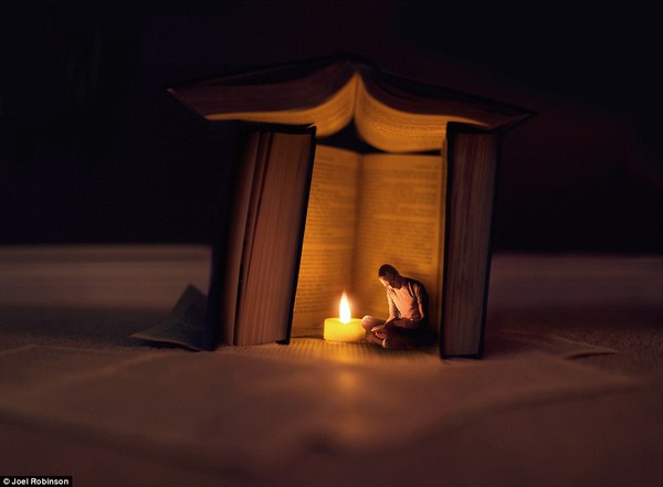 Night Times Stories: Joel is captured reading to a tea light sheltered by a fort of books