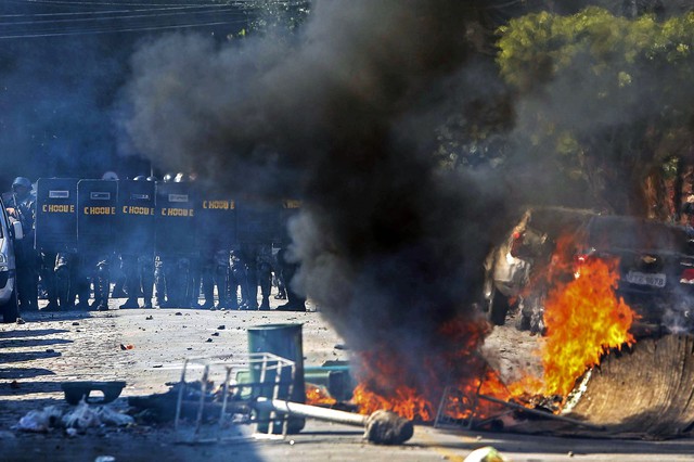 Cảnh sát chống bạo động đứng thành hàng rào chặn người biểu tình phản đối World Cup 2014 ở Sao Paulo, Brazil.