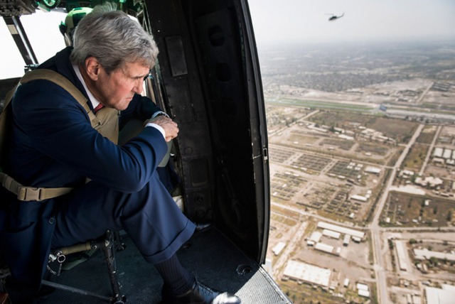 Ngoại trưởng Mỹ John Kerry nhìn ra ngoài một chiếc trực thăng trong khi bay thị sát trên bầu trời Baghdad, Iraq.