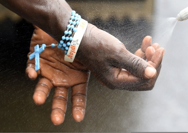 Nhân viên y tế rửa tay sau khi liệm thi thể một bệnh nhân Ebola tại Monrovia, Liberia.