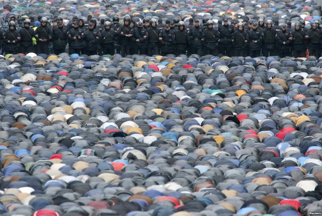 Cảnh sát Bộ Nội vụ Nga đứng bảo vệ khi những người theo đạo Hồi tham gia cầu nguyện tập thể trong dịp lễ Eid al-Adha, Moscow.
