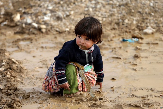 Bé gái người Syria ngồi chơi trên bùi đất tại một trại tị nạn ở thị trấn Al-Faour, Li Băng.