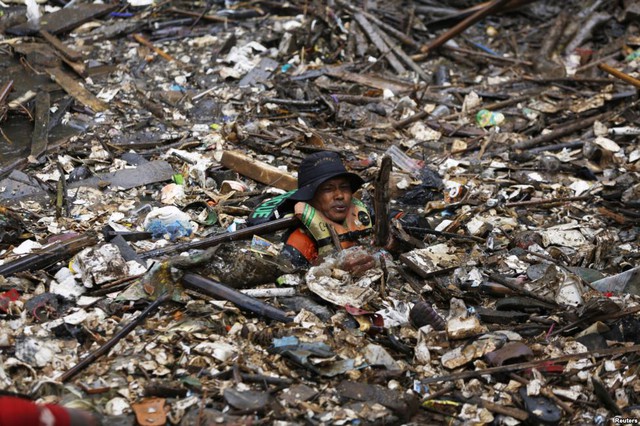 Một người tình nguyện dọn rác dưới sông Ciliwung ở quận Jatinegara của thành phố Jakarta, Indonesia.