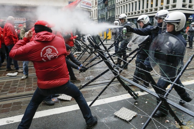 Cảnh sát chống bạo động xịt hơi cay vào người biểu tình trong cuộc đụng độ trên đường phố ở Brussels, Bỉ. Người biểu tình phản đối các biện pháp khắc khổ  của chính phủ.