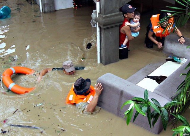 Cảnh sát giúp sơ tán các nạn bị mắc kẹt trong ngôi nhà ngập lụt của họ ở Misamis Oriental, đảo Mindanao, Philippines.