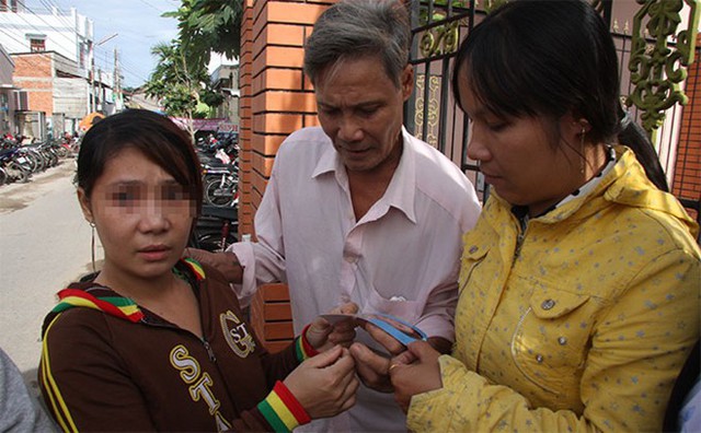 Chị Sen (bìa trái) cùng cha và chị trước trụ sở công an xã Bình Đức, huyện Châu Thành ngày 10/7 