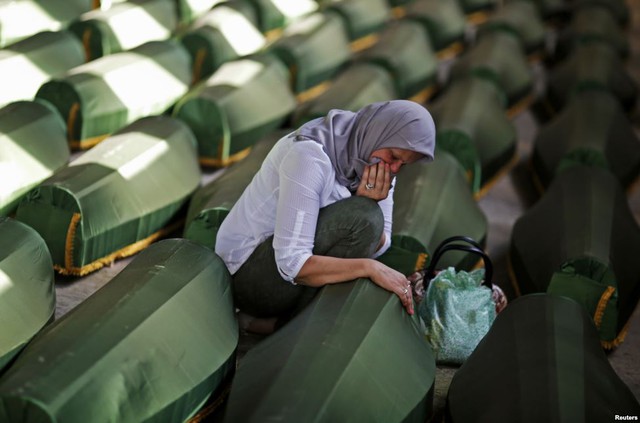 Một phụ nữ người Bosnia ngồi khóc cạnh quan tài người thân thiệt mạng trong vụ thảm sát Srebrenica năm 1995.