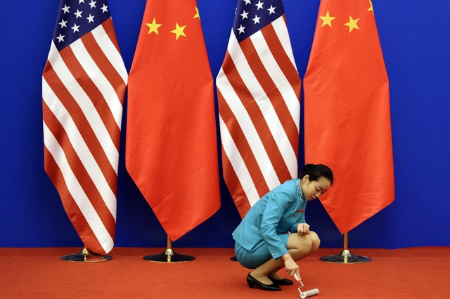 Một nhân viên phục vụ làm sạch thảm đỏ trước một cuộc họp vào về Đối thoại kinh tế và chiến lược Mỹ-Trung ở Bắc Kinh, Trung Quốc.