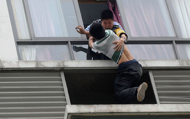 Cảnh sát túm một người đàn ông cố nhảy khỏi tầng 7 của một khách sạn ở Thành Đô, Trung Quốc.