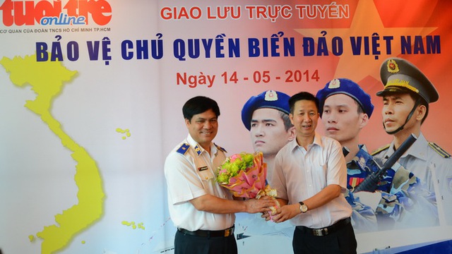 Tổng biên tập báo Tuổi Trẻ Phạm Đức Hải (phải) tặng hoa cho Thiếu tướng Nguyễn Quang Đạm - Tư lệnh Cảnh sát biển Việt Nam - Ảnh: Quang Định