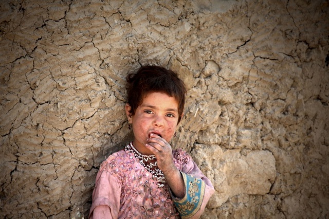 Bé gái tị nạn đến từ tỉnh Helmand đứng bên ngoài ngôi nhà tạm ở ngoại ô Kabul, Afghanistan.