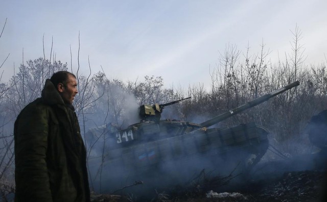 Người đàn ông đứng cạnh chiếc xe tăng của lực lượng ly khai thân Nga đang di chuyển gần ngôi làng Rozsypne, miền đông Ukraine.
