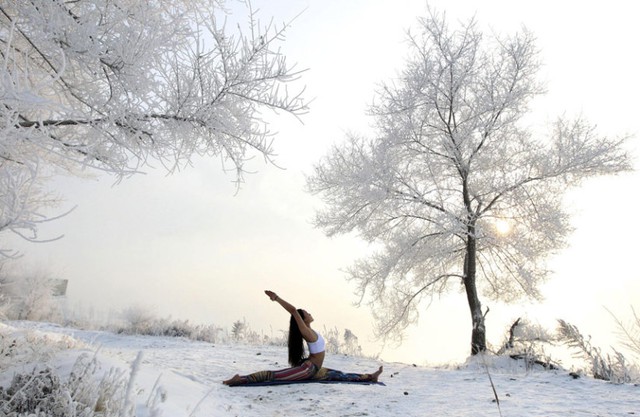 Xie Xiaoming, 26 tuổi, tập yoga trên bờ sông Tùng Hoa phủ đầy tuyết tại tỉnh Cát Lâm, Trung Quốc.