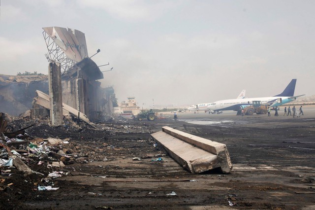 Máy bay đỗ gần tòa nhà bị phá hủy tại sân bay quốc tế Jinnah ở Karachi, Pakistan, sau khi bị phiến quân Taliban tấn công.