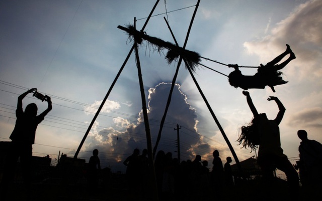 Bé gái chơi đánh đu trong khi bé trai thả diều trong dịp lễ hội Dashain của người theo đạo Hindu ở Katmandu, Nepal.