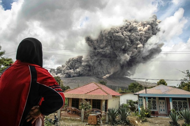 Người dân nhìn núi lửa phun trào tro bụi Sinabung , từ ngôi làng Karo ở North Sumatra, Indonesia.