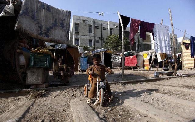 Cậu bé chơi bên ngoài những ngôi nhà tạm ở ngoại ô thành phố Peshawar, Pakistan.