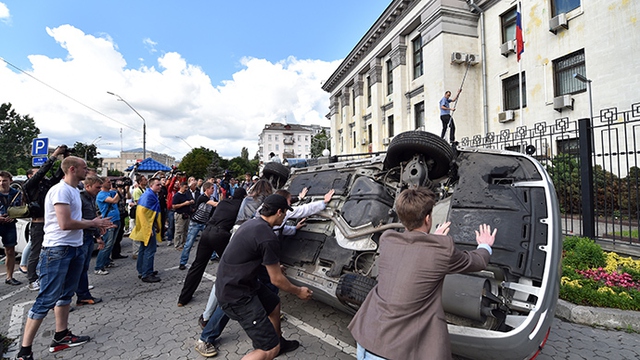 Người biểu tình Ukraine lật đổ ô tô trước tòa nhà đại sứ quán Nga tại thủ đô Kiev.