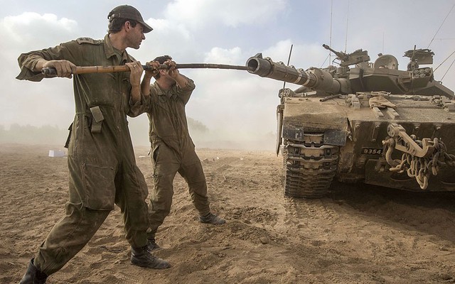 Các binh sĩ Israel thông nòng pháo xe tăng Merkava tại một điểm triển khai quân đội gần biên giới Israel-Dải Gaza.