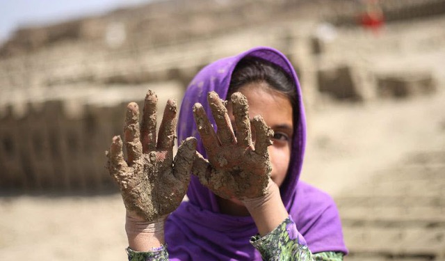 Bé gái làm việc trong một nhà máy sản xuất gạch ở Kabul, Afghanistan.