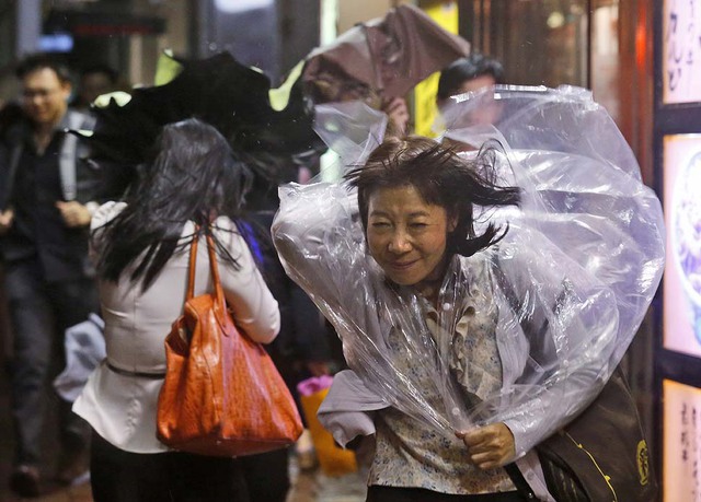 Một người phụ nữ vất vả chống chọi với gió bão mạnh ở Hong Kong, Trung Quốc.