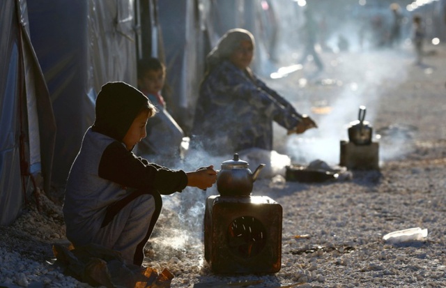 Người tị nạn từ thị trấn Kobani ở Syria chuẩn bị trà nóng trong một trại tị nạn ở Suruc, Thổ Nhĩ Kỳ.