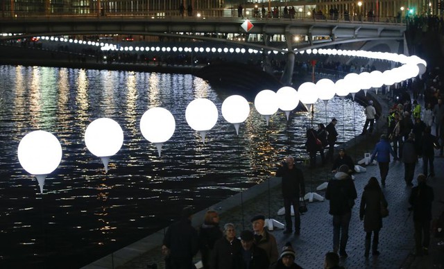 Mọi người đi dưới những quả bóng bay phát sáng dọc sông Spree ở Berlin, Đức. Những quả bóng bay này là tác phẩm nghệ thuật sắp đặt được trưng bày nhân dịp kỷ niệm 25 năm ngày bức tường Berlin sụp đổ.