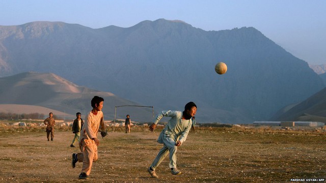 Trẻ em chơi bóng đá trên cánh đồng gần một ngôi làng ở ngoại ô thị trấn Mazar-i-Sharif, Afghanistan.