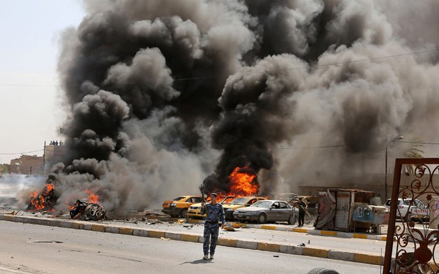 Cảnh sát đứng bảo vệ hiện trường vụ đánh bom hàng loạt tại thành phố Sadr, Baghdad, Iraq.