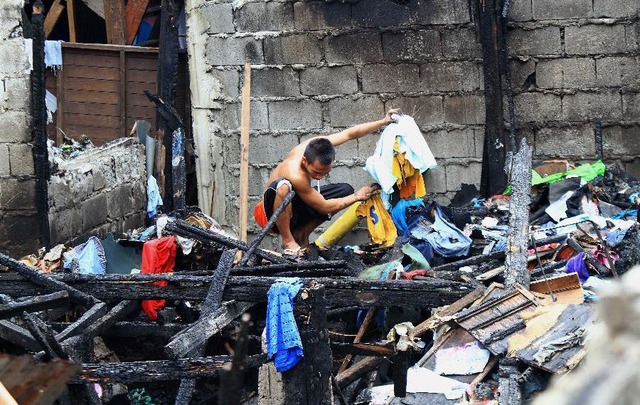 Người dân tìm kiếm những đồ còn dùng được sau vụ hỏa hoạn tại khu ổ chuột ở thành phố Mandaluyong, Philippines.