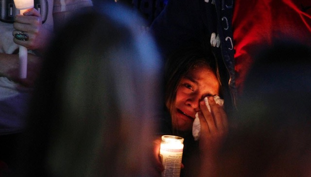 Một thiếu nữ lau nước mắt khi tham gia lễ thắp nến tưởng niệm nạn nhân thiệt mạng trong vụ xả súng tại trường trung học Reynolds ở Troutdale, bang Oregon, Mỹ.