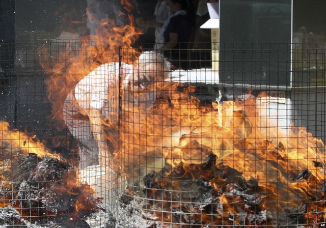 Một người đàn ông đốt đồ mã trong tháng cô hồn ở Đài Bắc, Đài Loan.