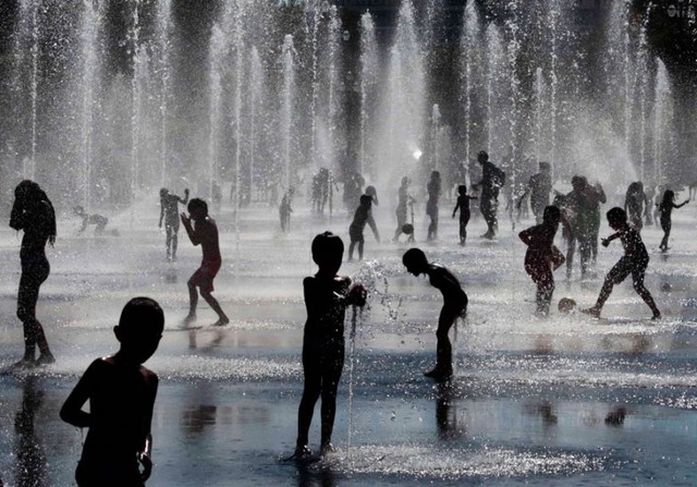 Trẻ em chơi trong đài phun nước dưới trời nắng nóng ở Nice, Pháp.