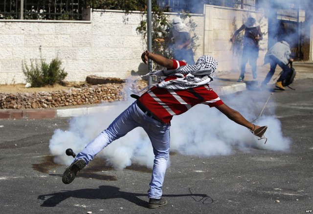 Những người biểu tình Palestine ném đá vào binh sĩ Israel, sau lễ tang của một thanh niên người Palestine tại trại tị nạn Amari ở thành phố Ramallah, Bờ Tây.